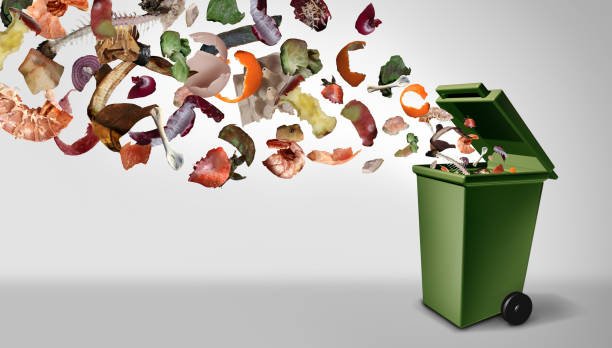 vegetable garbage falling into a green bin